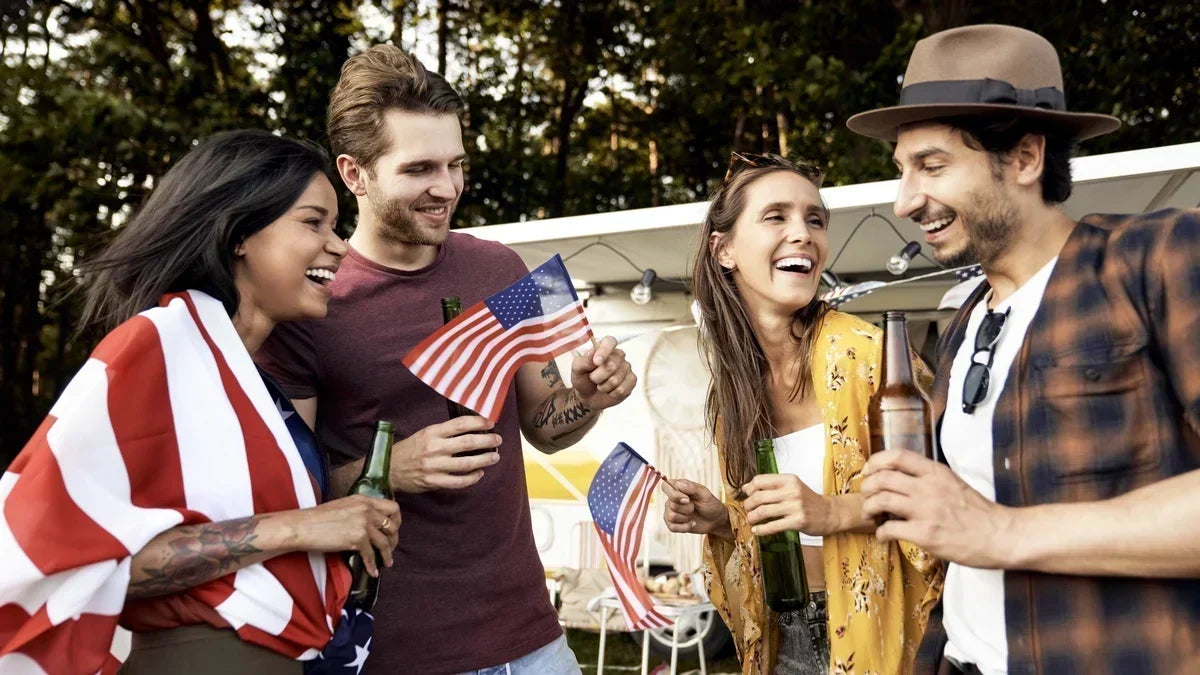 Four people celebrating 4th of July together, laughing together and having some drinks. 