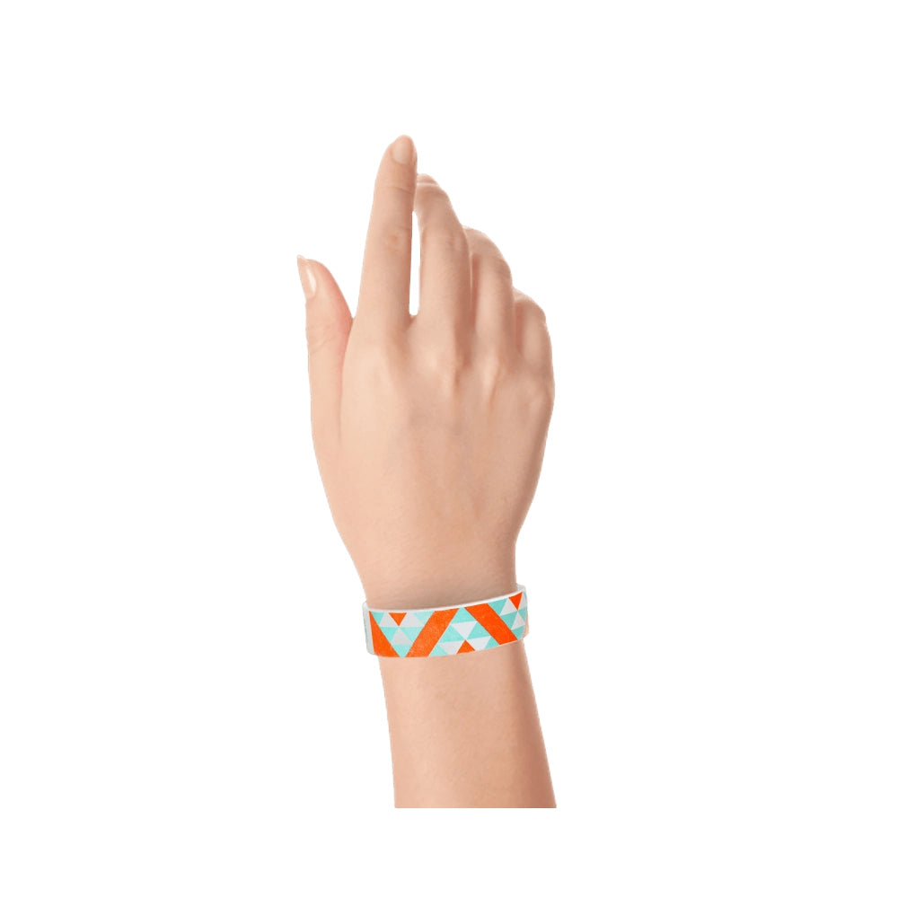 Wrist with aqua and neon orange aztec pattern on a white tyvek wristband 