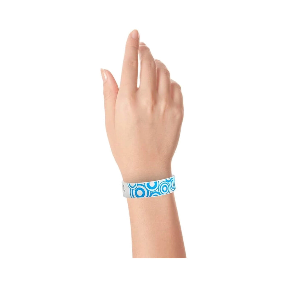 wrist showing a white tyvek wristband with a neon blue disk pattern