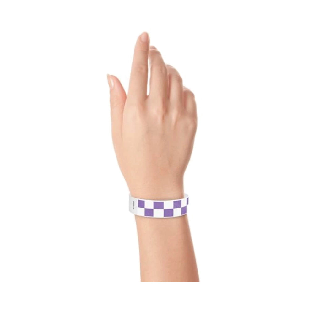Hand wearing a purple and white checkered wristband 
