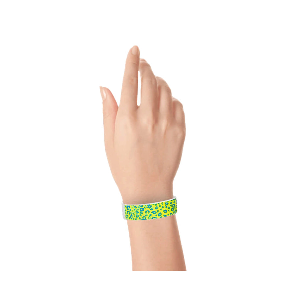 Hand wearing aqua and neon yellow cheetah patterned tyvek wristband 