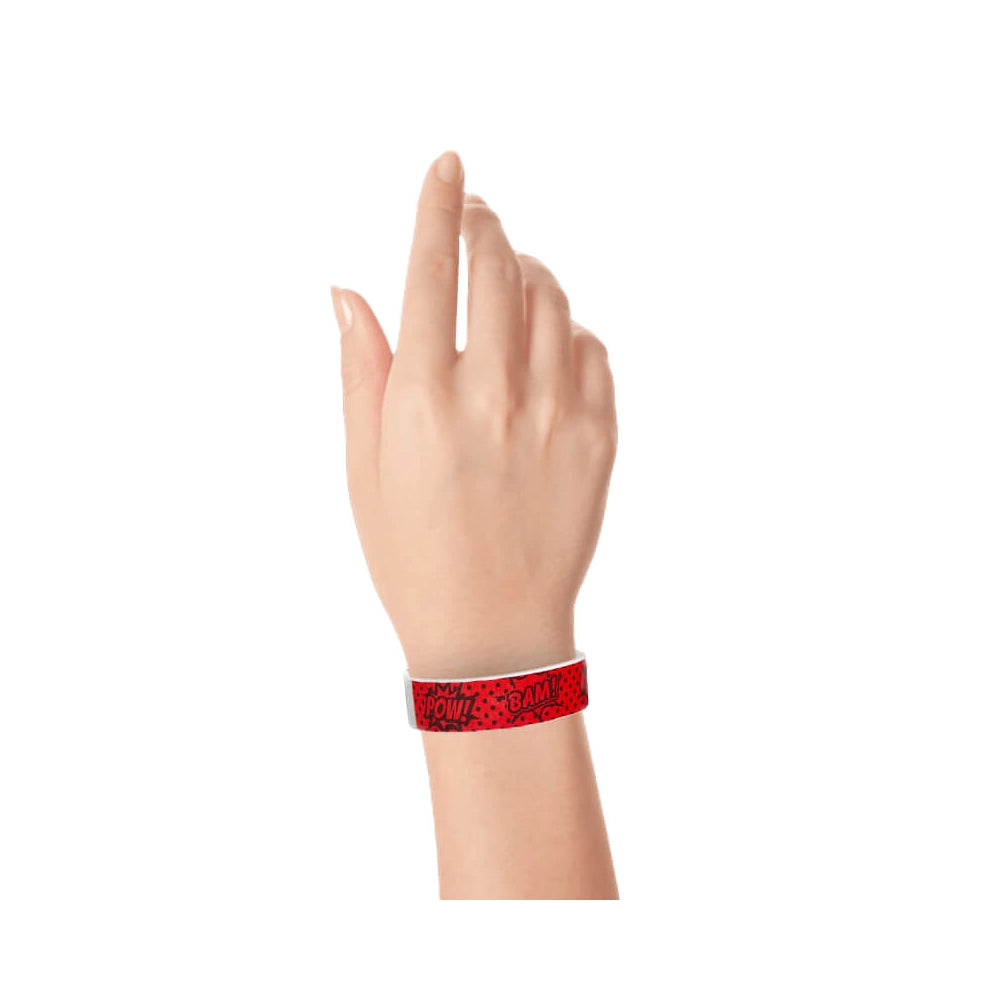 hand wearing a coming superhero pattern in neon red with black design tyvek wristband