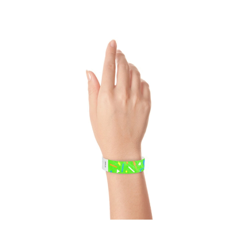 wrist wearing a neon green tyvek wristband in a confetti pattern with neon orange, neon blue, neon yellow and white