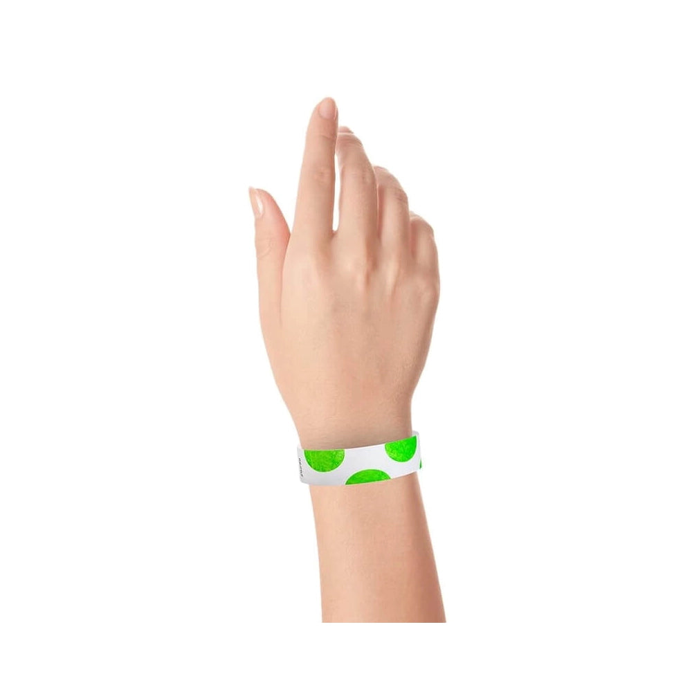 hand wearing a white tyvek wristband with neon green half circles