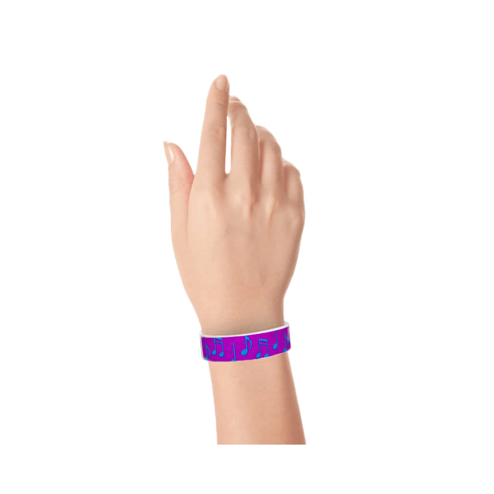 hand wearing a pantone purple tyvek wristband with a music note pattern in neon blue
