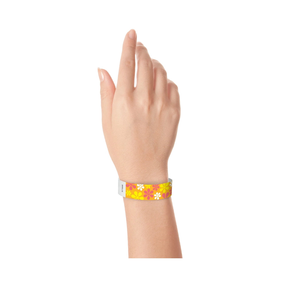 Tyvek 3/4 wristband in orange with white, yellow and pink flowers printed on the band - shown on wrist